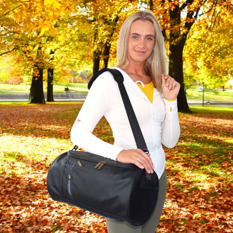 May include: A black cylindrical travel bag with a shoulder strap. The bag has a zippered pocket on the front and a gold logo that says "Travelpro".