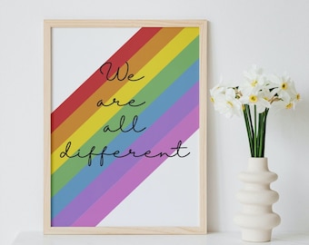 Könnte beinhalten: Ein gerahmter Druck mit einem Regenbogen-Design und dem kursiven Text "We are all different". Der Regenbogen verläuft diagonal über den Druck. Rechts befindet sich eine weiße Vase mit weißen Blumen.