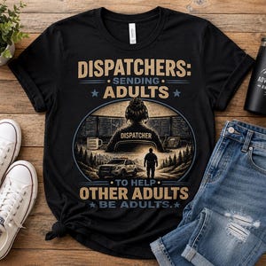 May include: Black t-shirt with a graphic design featuring a dispatcher, a police car, and the text "DISPATCHERS: SENDING ADULTS TO HELP OTHER ADULTS BE ADULTS." Also includes a black tumbler with the text "ADVENTURE AWAITS."