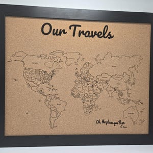 May include: A corkboard with a world map printed on it. The corkboard is framed in black and has the words "Our Travels" printed at the top. The quote "Oh, the places you'll go" is printed at the bottom.