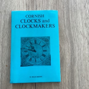 May include: A turquoise blue book titled "Cornish Clocks and Clockmakers" with a black and white image of a clock face on the cover. The author is H. Miles Brown.