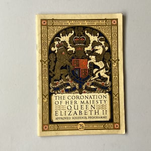 May include: A vintage programme for the coronation of Queen Elizabeth II. The cover features the royal coat of arms in gold and red with a lion and unicorn. The text reads "The Coronation of Her Majesty Queen Elizabeth II. Approved Souvenir Programme. King George's 2/6 Jubilee Trust."