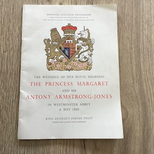 May include: A souvenir programme from the wedding of Princess Margaret and Mr Antony Armstrong-Jones, held at Westminster Abbey on 6 May 1960. The program features the royal coat of arms and text in red and black.