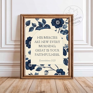 May include: A framed print featuring a floral design with navy blue flowers and leaves on a cream background. The print includes the text "HIS MERCIES ARE NEW EVERY MORNING; GREAT IS YOUR FAITHFULNESS." from Lamentations 3:23.