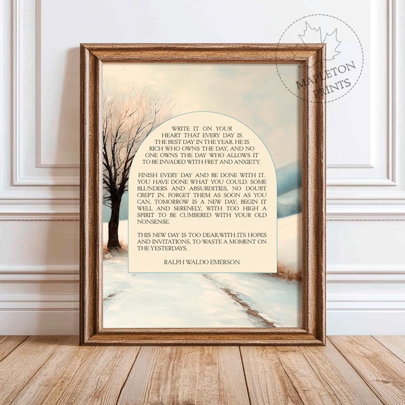 May include: A framed print with a quote by Ralph Waldo Emerson about living in the present moment. The quote is set against a snowy landscape with a bare tree in the foreground. The print has a light brown background and a white border.