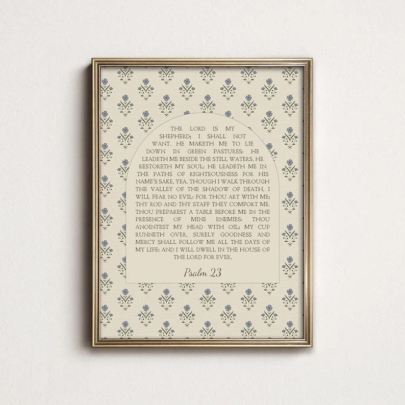 May include: A framed wall art print featuring a cream background with a repeating pattern of small blue floral sprigs. Centered is an arched beige panel containing the full text of Psalm 23 in black serif font, ending with the title Psalm 23.