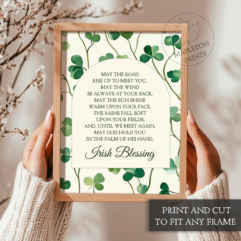 May include: A printable art print with a white background and a green shamrock pattern. The print features an Irish blessing poem with the text "May the road rise up to meet you. May the wind be always at your back. May the sun shine warm upon your face. The rains fall soft upon your fields. And, until we meet again, may God hold you in the palm of his hand. Irish Blessing".