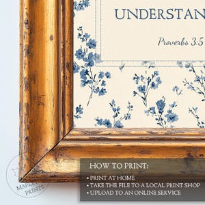 May include: A framed print with a floral design and the text "UNDERSTAND Proverbs 3:5". The print has a cream background with blue floral accents and is encased in a gold-colored wooden frame. The bottom of the frame has instructions on how to print the image.