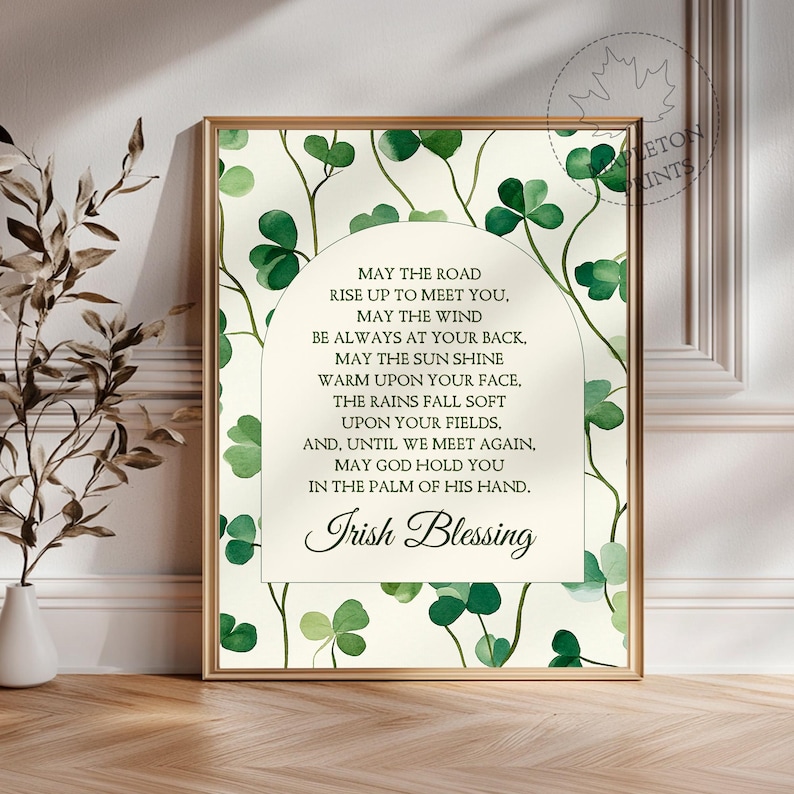 May include: A printable art print with a watercolor background of green shamrocks and a white arch with an Irish blessing. The text reads: "May the road rise up to meet you. May the wind be always at your back. May the sun shine warm upon your face. The rains fall soft upon your fields. And, until we meet again, may God hold you in the palm of his hand. Irish Blessing."