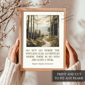 May include: A framed print with a quote by Ralph Waldo Emerson: "Do not go where the path may lead, go instead where there is no path and leave a trail." The print features a painting of a path through a forest.