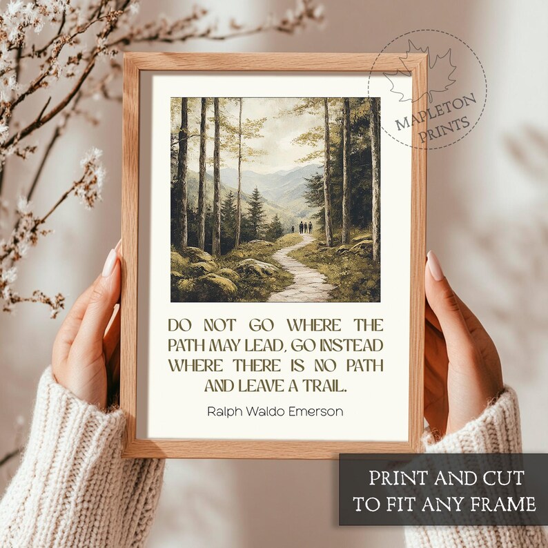 May include: A framed print with a quote by Ralph Waldo Emerson: "Do not go where the path may lead, go instead where there is no path and leave a trail." The print features a painting of a path through a forest.