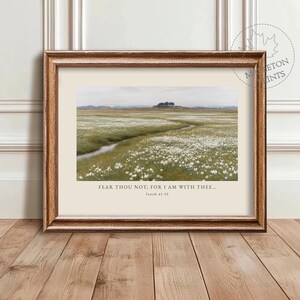 May include: A framed print depicting a landscape with a field of white flowers and a stream. The text "FEAR THOU NOT; FOR I AM WITH THEE... Isaiah 41:10" is printed below the image. The frame is a warm brown colour.