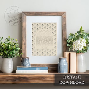 May include: A framed wall art print featuring the text of Psalm 23 centered within an arched design on a beige background with a repeating blue floral pattern. The print is housed in a dark brown wooden frame with a white mat border.