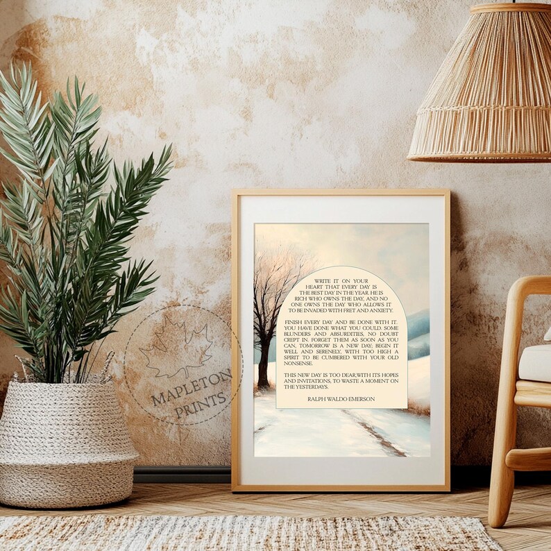 May include: A framed print with a quote by Ralph Waldo Emerson about living in the present moment. The quote is set against a watercolor background of a snowy landscape with two trees.