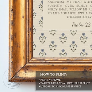 May include: A framed wall art piece featuring a cream-colored background with a repeating pattern of small blue flowers and green stems. The text reads Psalm 23 and includes verses from the Bible. The frame is gold with a distressed, weathered finish.