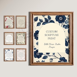 May include: A selection of framed scripture prints. The large print has a floral design with navy blue flowers and leaves. Text on the print reads "CUSTOM SCRIPTURE PRINT" and "Bible Verse . Psalm . Prayer". Smaller prints with various floral and patterned backgrounds are also shown.