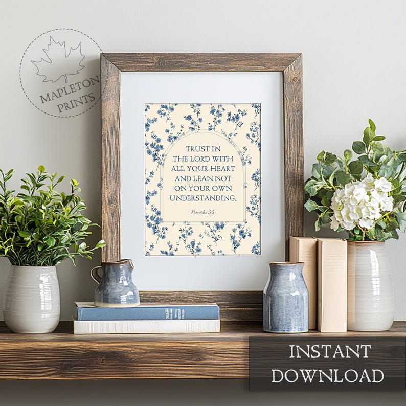 May include: A framed print with the text "Trust in the Lord with all your heart and lean not on your own understanding." The print has a floral design in blue on a cream background. The frame is brown. The words "Instant Download" are at the bottom.