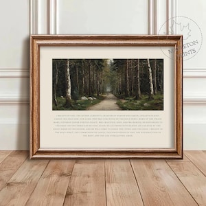May include: A framed print featuring a serene forest path scene. The artwork is set within a wooden frame and includes text at the bottom. The text is a religious creed. The print is displayed on a wooden surface.