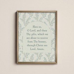 Op de afbeelding: Een rechthoekige wandkunstprint in een gouden lijst met een lichtgroene achtergrond en een herhalend patroon van kleine blauwe blaadjes. In het midden staat een boogvormig paneel met de tekst: Bless us, O Lord, and these Thy gifts, which we are about to receive from Thy bounty, through Christ our Lord. Amen.