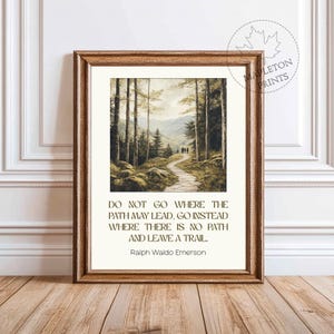 May include: A framed print with a quote by Ralph Waldo Emerson: "Do not go where the path may lead, go instead where there is no path and leave a trail." The print features a painting of a forest path with people walking on it.