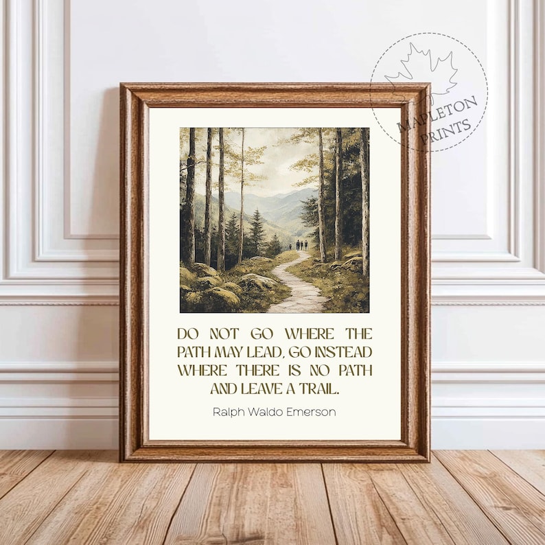 May include: A framed print with a quote by Ralph Waldo Emerson: "Do not go where the path may lead, go instead where there is no path and leave a trail." The print features a painting of a forest path with people walking on it.