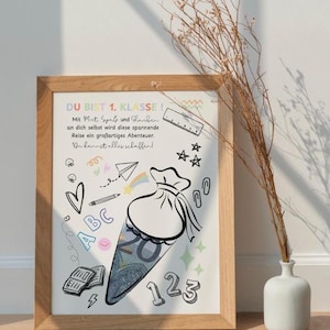 Puede incluir: Un estampado enmarcado con un marco de madera clara. El estampado presenta una ilustraci&oacute;n de dibujos animados de un cono escolar lleno de dinero, rodeado de garabatos como corazones, estrellas y n&uacute;meros. El texto en alem&aacute;n dice "DU BIST 1. KLASSE!" y otras frases.