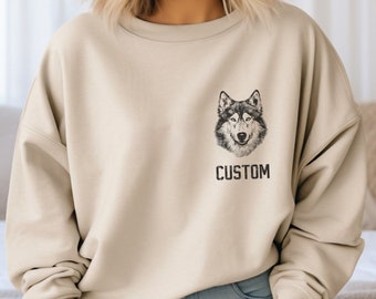 May include: Beige sweatshirt featuring a detailed black and white wolf illustration and the word "CUSTOM" printed below. The sweatshirt is a neutral color and has a relaxed fit.