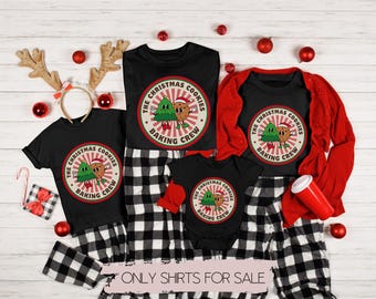 Pode incluir: Um conjunto de quatro t-shirts pretas com um design de biscoitos de Natal. As t-shirts apresentam uma árvore de Natal verde e um biscoito de gengibre de mãos dadas. O texto nas t-shirts diz "The Christmas Cookies Baking Crew".