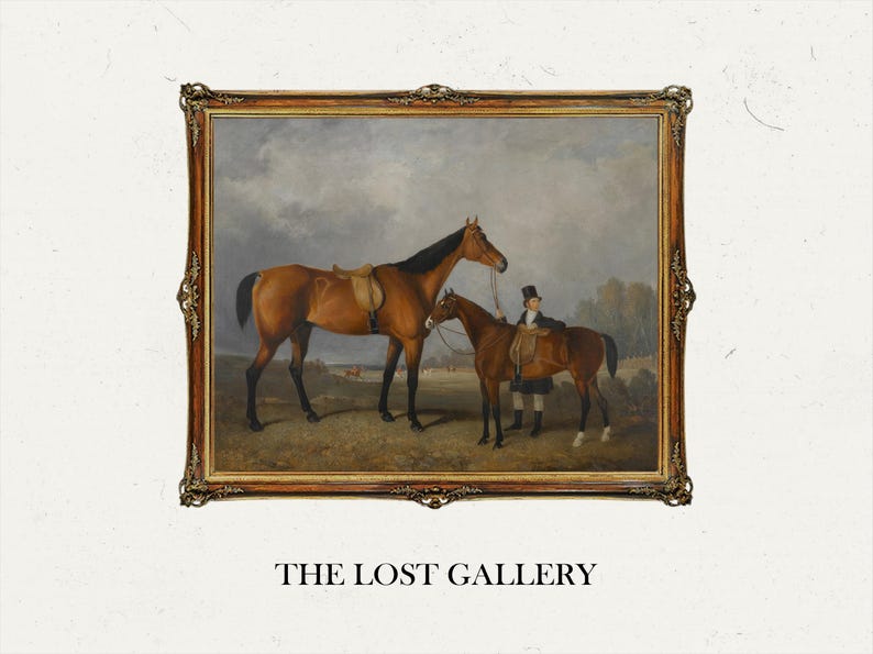 May include: A framed oil painting depicting two brown horses with a rider in a field. The painting is in a gold frame with ornate details. The text "THE LOST GALLERY" is below the frame.