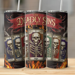 May include: Three stainless steel tumblers with a black background and flames at the bottom. The tumblers feature a red banner with the text "THE DEADLY SINS" and seven playing cards with skeletons and the seven deadly sins: Lust, Gluttony, Greed, Anger, Sloth, Envy, and Pride.