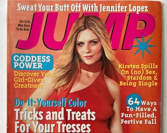 Può includere: Una copertina di rivista con una donna con un top rosso e pantaloni floreali. Il titolo della rivista è "JUMP" in grandi lettere rosa. I titoli includono "Sweat Your Butt Off With Jennifer Lopez" e "Do-It-Yourself Color Tricks and Treats For Your Tresses."