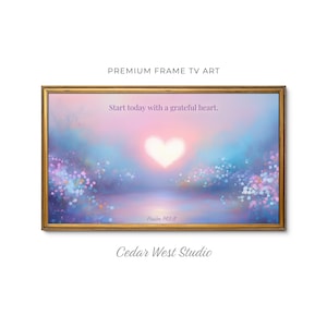 May include: A framed art print with a gold-colored frame. The artwork features a heart-shaped light in a pastel sky with the text "Start today with a grateful heart." and "Psalm 143:8". The bottom of the frame has the text "Cedar West Studio".