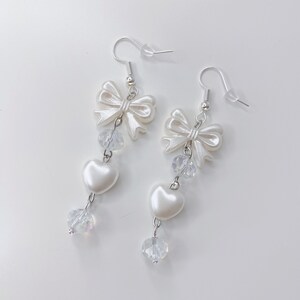 White earrings with a pearl bow, iridescent earrings and pearl hearts.