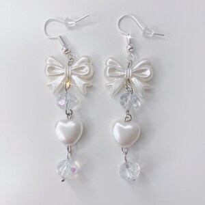 White earrings with a pearl bow, iridescent earrings and pearl hearts.