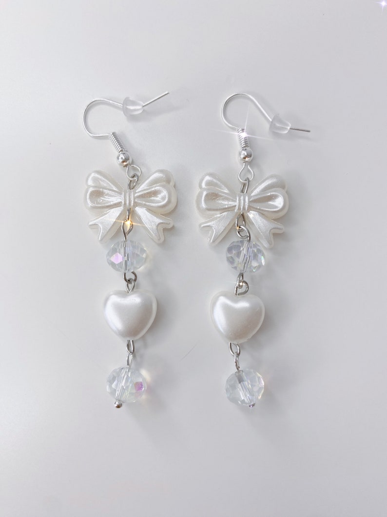 White earrings with a pearl bow, iridescent earrings and pearl hearts.