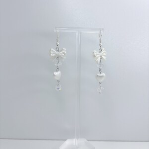 White earrings with a pearl bow, iridescent earrings and pearl hearts.