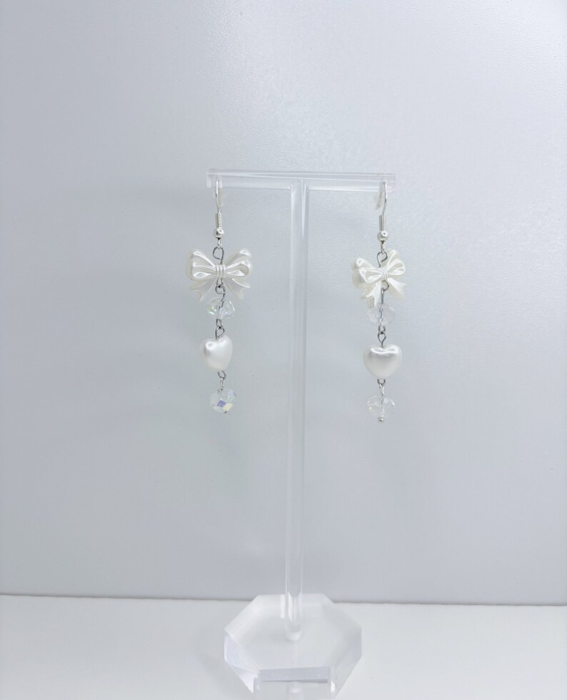 White earrings with a pearl bow, iridescent earrings and pearl hearts.