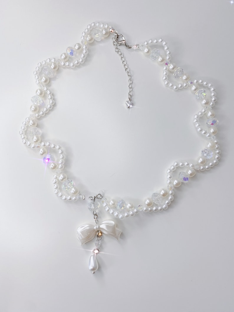 A white pearl twirl necklace with iridescent beads and pearl bows.