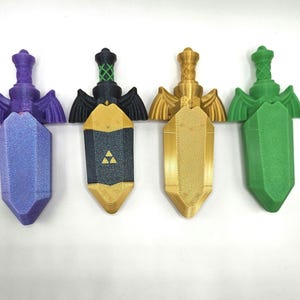 May include: Four decorative sword pendants in purple, black and gold, gold, and green. Each pendant has a detailed hilt and wings. The blades are geometric. The black and gold pendant has a triangle symbol. The pendants are for decoration.