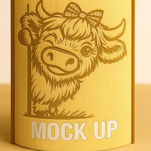 May include: A yellow, cylindrical box with a cartoon cow illustration and the text "MOCK UP". The cow has a bow and is smiling. The box has a ribbed texture and a brown border.