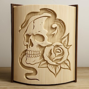 May include: A wooden decorative box with a carved design featuring a skull, a rose, and a snake. The box has a light brown front with a dark brown frame. The skull has detailed teeth and is surrounded by the rose and snake.