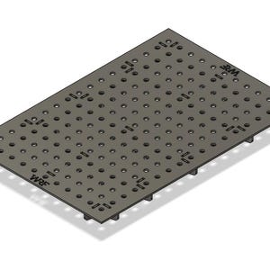 Pode incluir: Uma placa metálica retangular cinza com numerosos orifícios espaçados uniformemente e as letras "WRF" em dois cantos. A placa tem pequenos pés na parte inferior, projetada para uso em oficina ou industrial.
