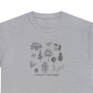 Może przedstawiać: Szary t-shirt z nadrukiem czarno-białej ilustracji r&oacute;żnych drzew i liści. Pod ilustracją znajduje się napis "CANOPY DREAMER".