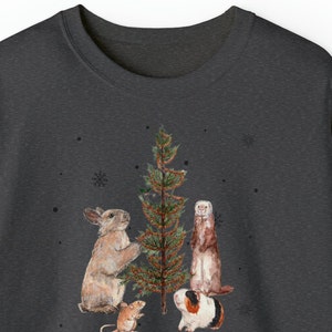 May include: A dark gray t-shirt with a Christmas tree and four animals decorating it. The animals are a rabbit, a ferret, a mouse, and a guinea pig. The text "HAVE A COOL YULE" is printed below the animals.