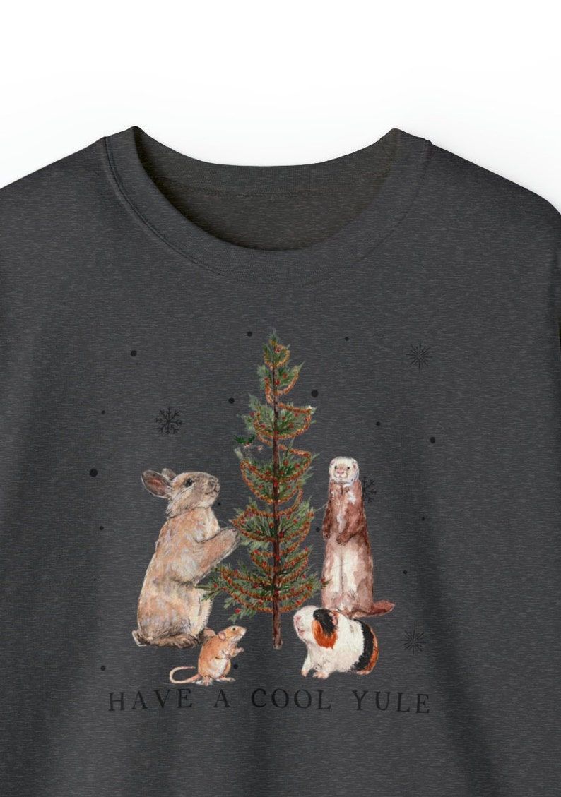 May include: A dark gray t-shirt with a Christmas tree and four animals decorating it. The animals are a rabbit, a ferret, a mouse, and a guinea pig. The text "HAVE A COOL YULE" is printed below the animals.