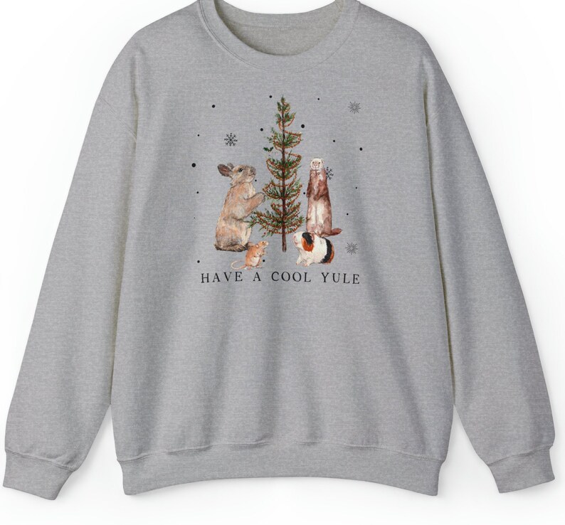 May include: A gray sweatshirt with a festive design featuring a rabbit, ferret, guinea pig, and a mouse decorating a Christmas tree. The text "HAVE A COOL YULE" is printed below the animals.