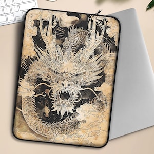 May include: A black and white laptop sleeve with a detailed illustration of a dragon on a beige background.