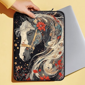 以下が含まれることがあります： 花柄のアクセントが施された馬の頭部のカラフルなイラストが描かれた黒いノートパソコン用スリーブ。馬は白黒の毛並みで、茶色の革の頭絡をしています。