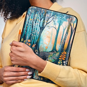 May include: A yellow sweater with a laptop sleeve featuring a colourful illustration of a forest with trees and foliage.