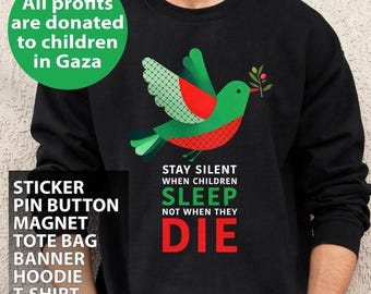 May include: Black sweatshirt featuring a green and red bird design with a sprig. The text on the sweatshirt says "Stay silent when children sleep, not when they die." Additional text indicates profits are donated to children in Gaza.